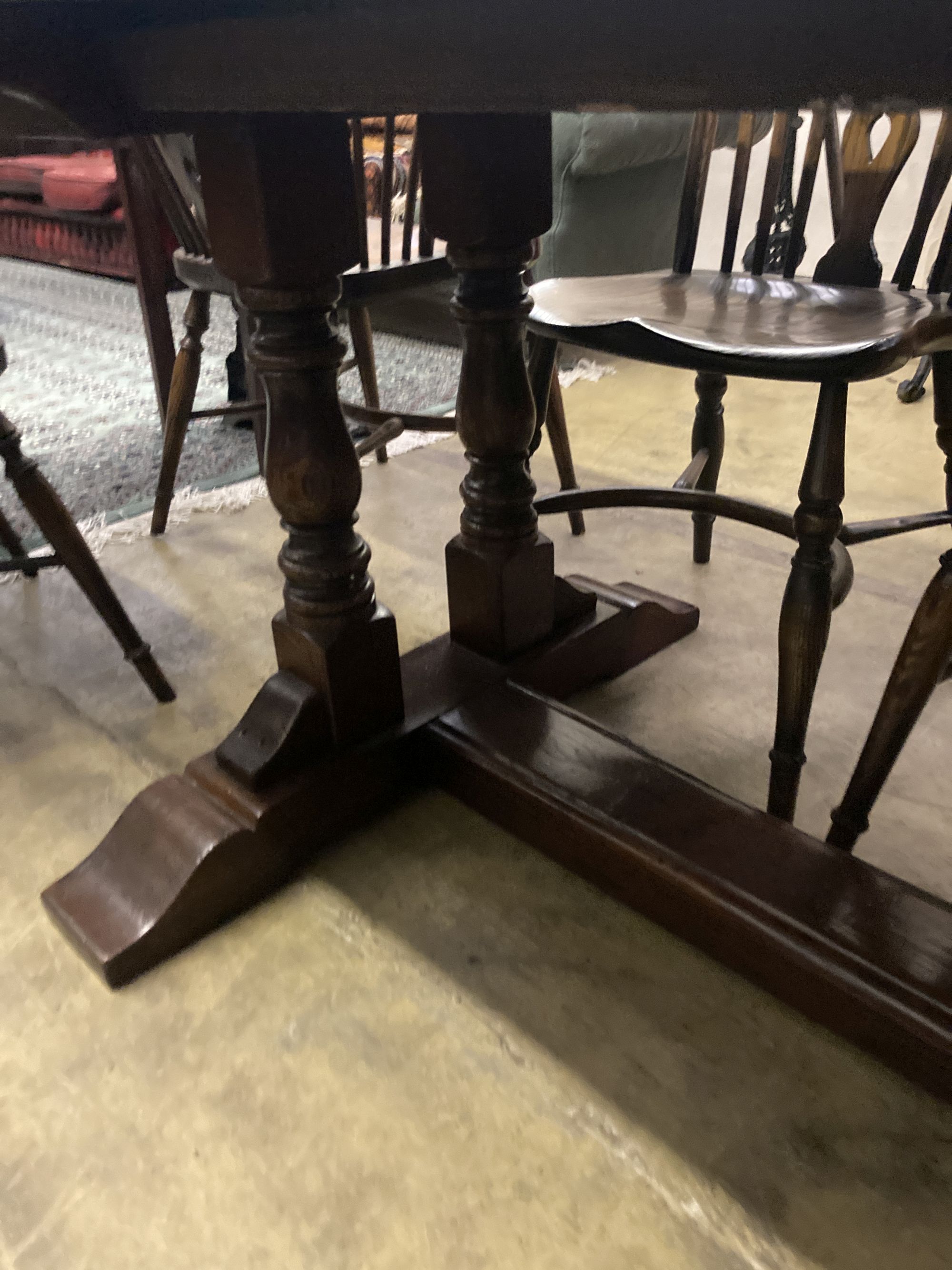An 18th century style oak refectory table having planked top on double turned end supports, width 230cm depth 90cm height 76cm